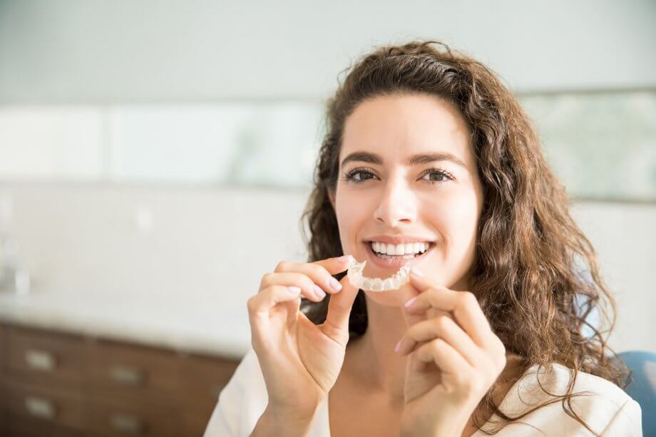 Middle-Aged Woman Holding Clear Braces