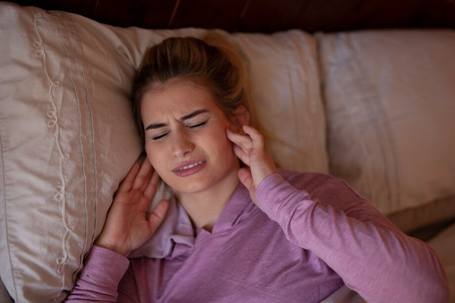 woman in bed with jaw pain