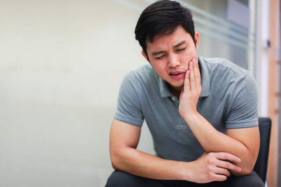 young man holding his jaw